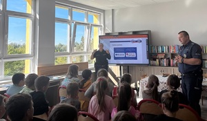 Dwójka policjantów podczas prelekcji w sali lekcyjnej