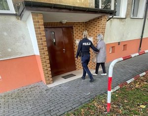 Umundurowana policjantka prowadzi kobietę