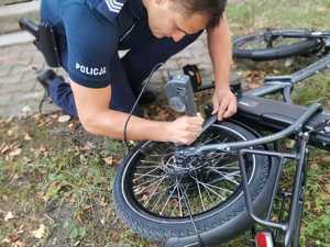 Policjant pochylony nad leżącym rowerem