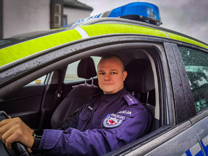 Młody policjant w radiowozie
