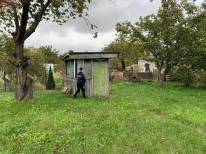 Policjantka przy starej altanie działkowej