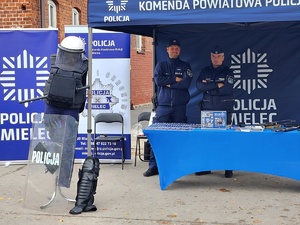Dwaj policjanci w niebieskim namiocie wystawienniczym policji