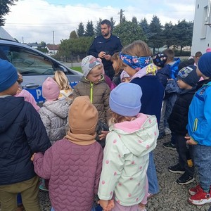 Policjant przy grupce dzieci w przestrzeni otwartej
