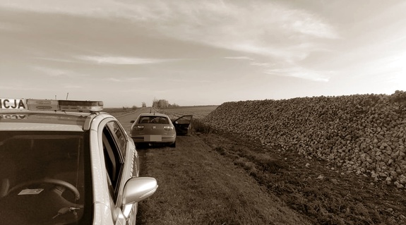 Pryzma buraków w polu, obok radiowóz i samochód osobowy