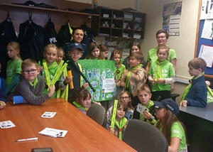 Grupa dzieci z wychowawczynią i policjantka w budynku komisariatu