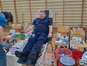 Policjant na fotelu podczas oddawania krwi