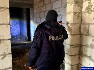 Widziany od tyłu policjant w pustych surowych pomieszczeniach