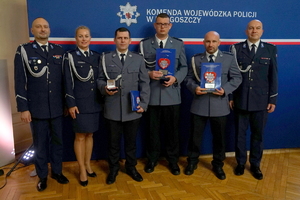 Szóstka policjantów pozująca do zdjęcia, trójka z nich w rękach trzyma odznaki