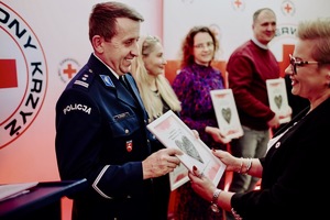 Uśmiechnięty policjant odbierający dyplom