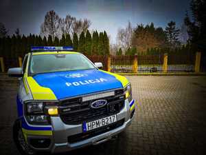 Radiowóz terenowy na tle zieleni parkingu