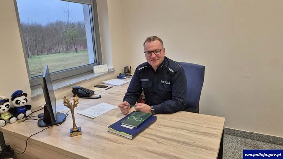 Uśmiechnięty policjant za biurkiem