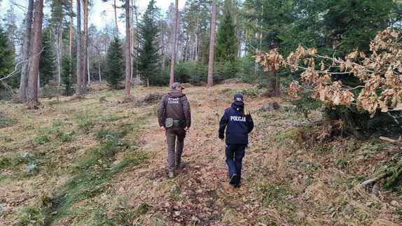 W scenerii leśnej policjantka i strażnik leśny.