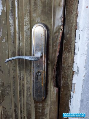 Zbliżenie klamki oraz futryny metalowych drzwi z odgiętą blachą