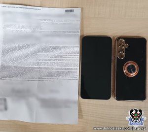 Karta papieru zapisana pismem maszynowym oraz smartfon