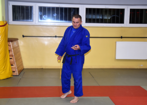 Mężczyzna w niebieskim kimonie na sali gimnastycznej