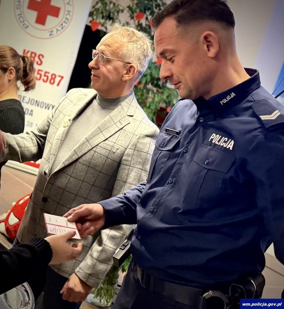 Policjant odbierający legitymację Zasłużonego Honorowego Dawcy Krwi