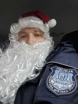 Policjant w czapce Mikołaja i srebrną brodą