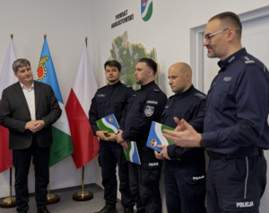 Czterej policjanci oraz mężczyzna w sali starostwa w Augustowie