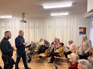 Dwóch policjantów podczas prelekcji dla grupy seniorów
