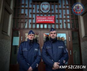 Dwóch policjantów na tle wejścia do komisariatu