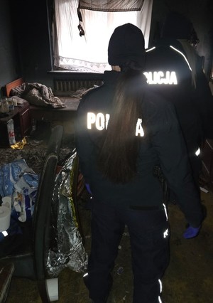 Widziane z tyłu dwie policjantki w pustostanie