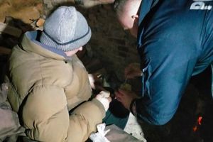 W scenerii nocnego pustostanu policjant pochylający się nad kobietą