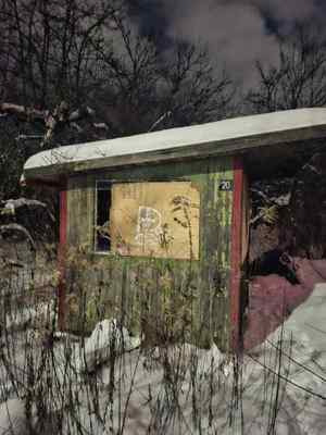 Rozpadająca się drewniana altana w scenerii zimowej