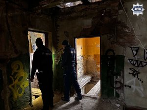 Dwaj policjanci wewnątrz zrujnowanego pustostanu