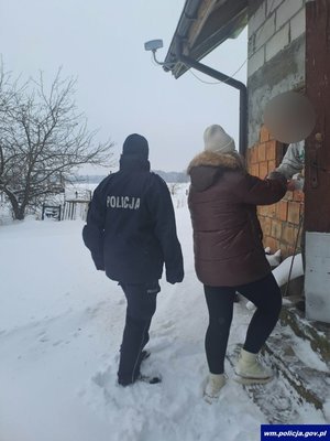 Kobieta i policjant przy drzwiach do budynku w scenerii zimowej otwartej przestrzeni