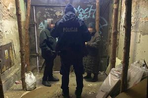 Dwoje starszych osób oraz policjant w zamkniętym przejściu typu brama