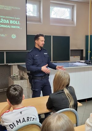 Policjant podczas prelekcji w sali szkolnej