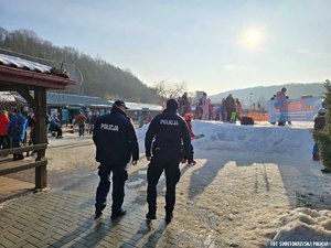 Widziani od tyłu dwaj policjanci na tle wejścia na teren rekreacyjny