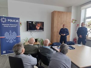 Dwaj policjanci podczas prelekcji dla grupy seniorów