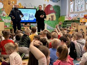 Dwóch policjantów podczas pogadanki dla grupy przedszkolaków