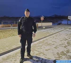 Nocą policjant na deptaku wzdłuż rzeki
