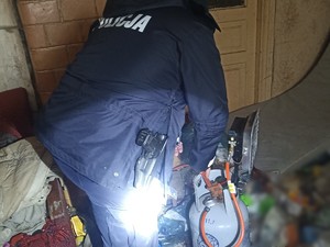 Policjant mocujący promiennik ciepli na butli gazowej