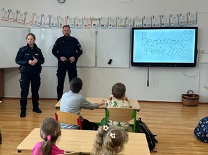 Dwójka policjantów podczas pogadanki dla dzieci w sali szkolnej
