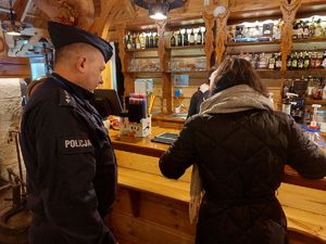 policjant oraz kobieta wewnątrz sklepu z alkoholami