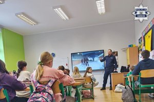 Policjant podczas prelekcji w sali szkolnej