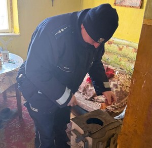 Policjant wewnątrz mieszkania rozpalający tzw. kozę