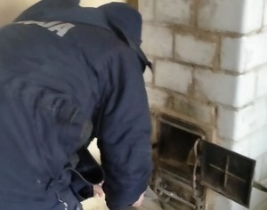 Policjant rozpalający piec kaflowy
