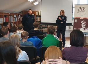 Dwójka policjantów podczas prelekcji dla młodzieży w bibliotece