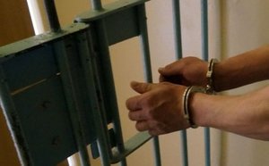 Skute ręce mężczyzny przy kracie aresztu