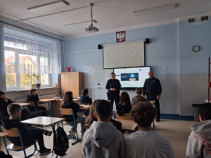 Dwójka policjantów podczas prelekcji w sali lekcyjnej