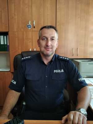 Uśmiechnięty policjant za biurkiem