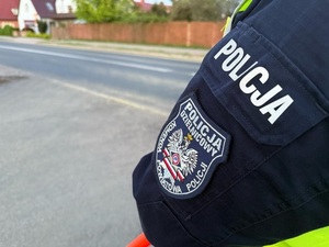 rękaw  kurtki policyjnej na tle jezdni
