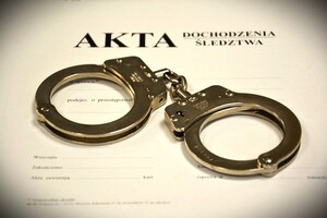 Kajdanki leżące na obwolucie akt dochodzenia