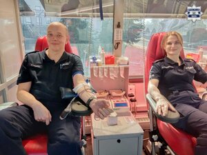 Uśmiechnięci policjantka i policjant w trakcie oddawania krwi