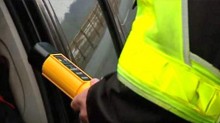 Zbliżenie rąk policjanta trzymających alkotest