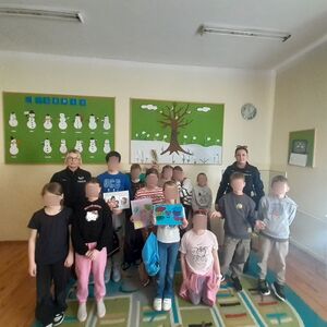 Dwie policjantki z grupą dzieci pozujących do zdjęcia